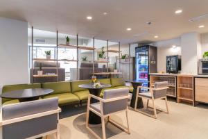 restauracja z zieloną kanapą, stołami i krzesłami w obiekcie ARTIEM Capri w mieście Mahón