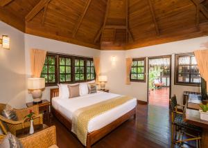 een slaapkamer met een groot wit bed in een kamer bij River Kwai Resotel in Sai Yok +39 foto's