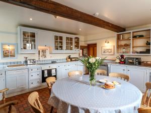 a kitchen with a table with a vase of flowers on it at Slade House in Ashbourne