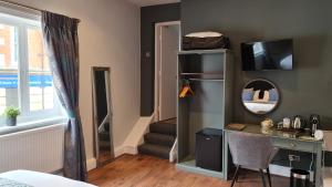 um quarto com uma secretária e uma escada com um espelho em The George Inn em Barton upon Humber