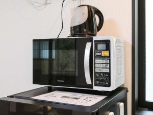 a microwave sitting on top of a black table at Kyo no yado BOTAN in Kyoto