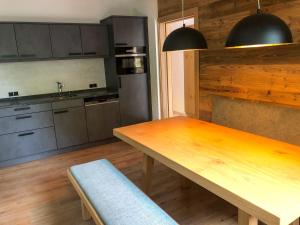 cocina con mesa de madera y suelo de madera en das Luggi Appartements, en Reith im Alpbachtal