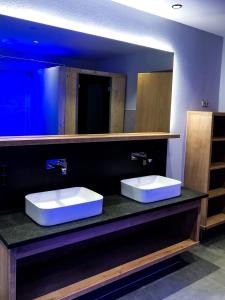 a bathroom with two sinks and a large mirror at das Luggi Appartements in Reith im Alpbachtal