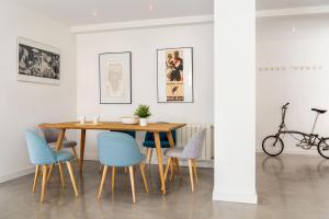 ein Esszimmer mit einem Holztisch und blauen Stühlen in der Unterkunft AlohaMundi Corral del Rey in Sevilla