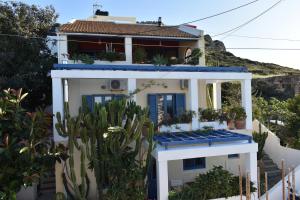 una casa blanca con puertas azules y cactus en Sissi View, en Sissi