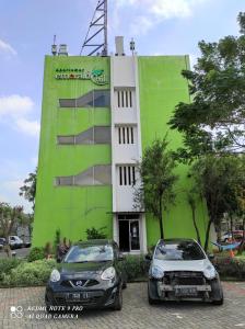 two cars parked in front of a building at Comfy Emerald Hill Karawang in Telukjambe
