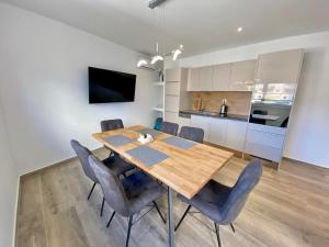 a kitchen and dining room with a wooden table and chairs at Apartman Terra in Medulin