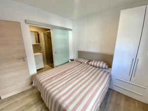 a small bedroom with a bed and a cabinet at Apartman Terra in Medulin