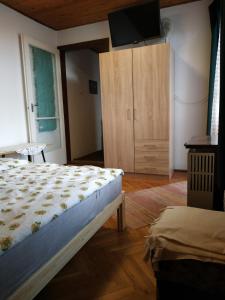 a bedroom with a bed and a cabinet with a television at Fonyód Nyaraló in Fonyód