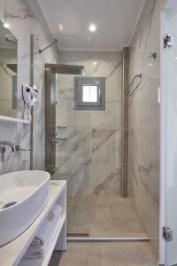 a bathroom with a shower and a white sink at ALKINOI RESORT AND SPA in Monemvasia