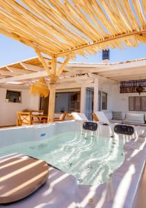 a hot tub in a patio with a wooden roof at The Roof-Top in Megalochori