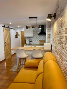 a living room with a yellow couch and a brick wall at Apartamento Mil Palmeras in Pilar de la Horadada