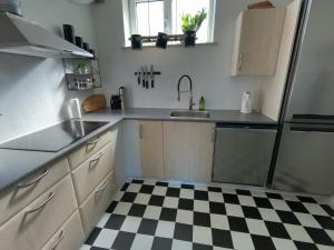 a kitchen with a black and white checkered floor at Thy Ferielejlighed in Thisted