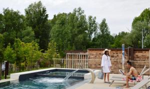 un homme et une femme debout à côté d'une piscine dans l'établissement Borgo Stazione Bike Inn, à Valeggio sul Mincio