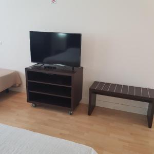 Ein Flachbildfernseher steht auf einem Ständer mit einer Bank. in der Unterkunft Hotel Puerta de la Serrania in Lliria