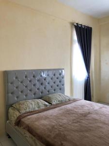 a large bed in a bedroom with a window at Comfy Emerald Hill Karawang in Telukjambe