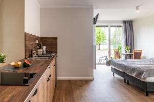a kitchen with a sink and a bed in a room at PARADISE Apartamenty in Charzykowy