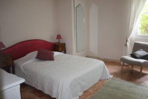 sypialnia z łóżkiem, krzesłem i oknem w obiekcie Grande maison au cadre verdoyant au centre village w mieście Cargèse