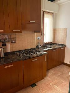 a kitchen with wooden cabinets and a stove top oven at Porta San Felicianetto Holiday Home in Foligno