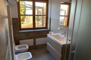 a bathroom with a sink and a toilet and a window at Maison Dahu - Sci, passeggiate e sport a Pila - Alloggio ad uso turistico - VDA - Gressan - n 0012 in Pila