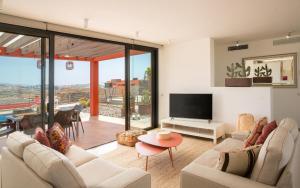 Sala de estar con 2 sofás y TV en Las Terrazas Villa 3 en Salobre