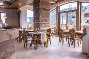 a restaurant with wooden tables and chairs and large windows at Yager Chalet in Poiana Brasov