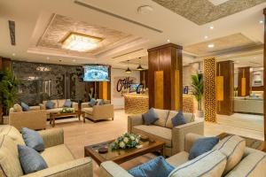 Red Sea Seasons Hotel Suites في جدة: غرفة معيشة كبيرة مع كنب وتلفزيون