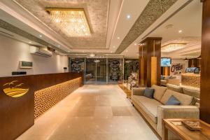 eine Lobby eines Hotels mit einem Sofa und einem Tisch in der Unterkunft Red Sea Seasons Hotel Suites in Dschidda