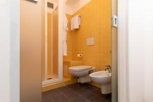 a yellow bathroom with a toilet and a sink at Albergo Nazionale in Portofino +20 photos
