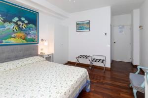 ポルトフィーノにあるアルベルゴ ナツィオナーレのベッドルーム1室(ベッド1台付)が備わります。壁には絵画が飾られています。