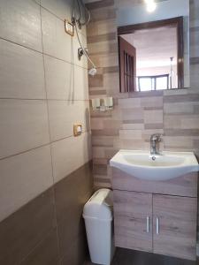 een badkamer met een wastafel, een toilet en een spiegel bij la casina rossa B&B "Da capachiatta" in San Sebastiano al Vesuvio
