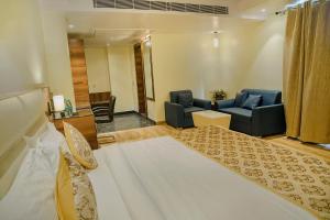 Habitación de hotel con cama y sala de estar. en Hotel Hira Inn-10mins From Railway Station & Bus Station, en Allahābād