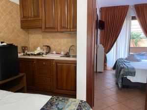 a kitchen with wooden cabinets and a sink in a room at EURO HOUSE INN airport in Fiumicino