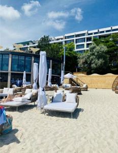 a group of lounge chairs and umbrellas on a beach at Одесса МАГНИТ у моря на пляже однокомнатные апартаменты 39 метров in Odesa