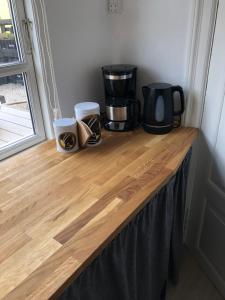 a counter with two coffee pots and a coffee maker on it at Stubbekøbingrooms in Stubbekøbing