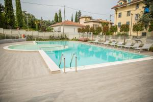 a swimming pool with chairs in a building at Homingarda Apartments, Pool & Garden, Near Lake Garda and Center in Peschiera del Garda