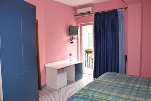 um quarto com paredes cor-de-rosa e azul e uma cama em Le Soleil B&B em Milazzo