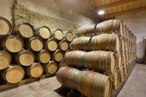 a bunch of wine barrels stacked in a room at Château de Melin in Auxey-Duresses