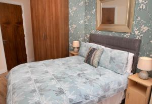 a bedroom with a bed with a blue and white comforter at Arch House Apartments in Athlone