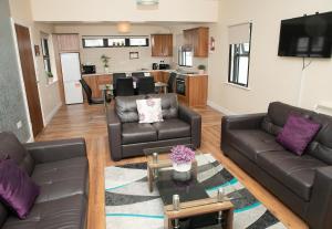 a living room with two leather couches and a kitchen at Arch House Apartments in Athlone