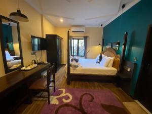 1 dormitorio con cama, escritorio y espejo en Beach Veli, en Ukulhas