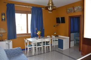 una sala da pranzo con tavolo bianco e tende blu di Le Soleil B&B a Milazzo