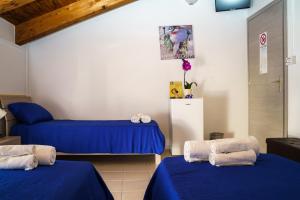 two beds in a room with blue sheets at Sansi´s Sapri Camere in Sapri