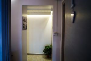 un corridoio con una porta che conduce a una stanza con una pianta di Sansi´s Sapri Camere a Sapri