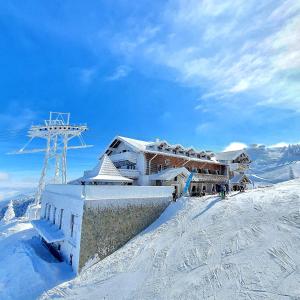 a building on the top of a snow covered mountain at Yager Chalet in Poiana Brasov