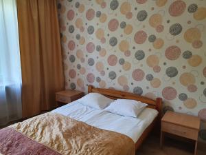 a bedroom with a bed and a wall covered in wallpaper at Hotel Iskra in Rzeszów