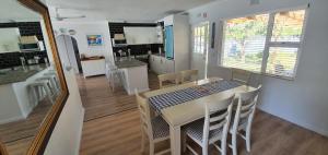 a kitchen and dining room with a table and chairs at Fredericks in Plettenberg Bay