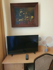 una TV a schermo piatto seduta sopra una scrivania di Hotel Iskra a Rzeszów
