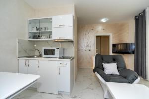 een woonkamer met een bank en een magnetron bij KAOM Lux in Dobra Voda