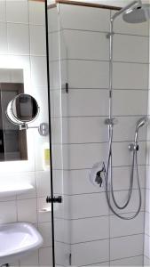 um chuveiro com uma porta de vidro ao lado de um lavatório em Rommentaler Burgstüble em Schlat